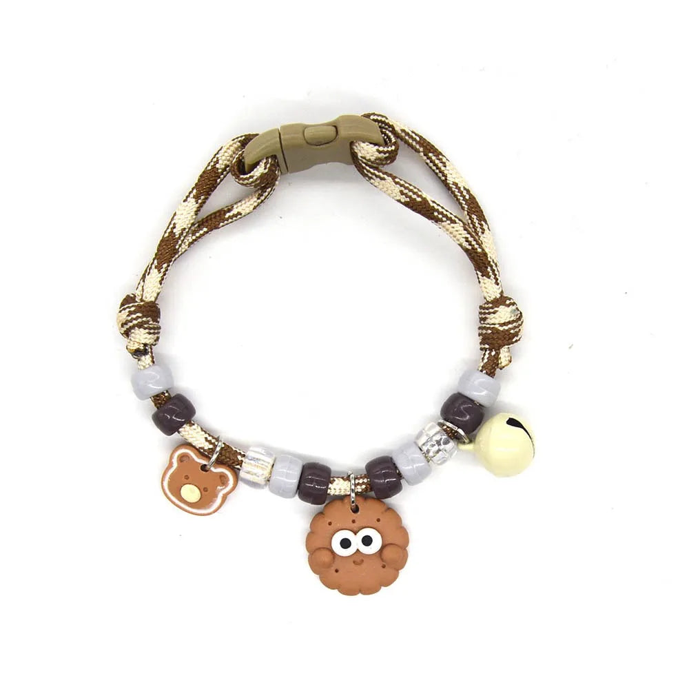 A colorful braided pet collar with a bell for cats and small dogs, featuring brown and white threads and a round bell.