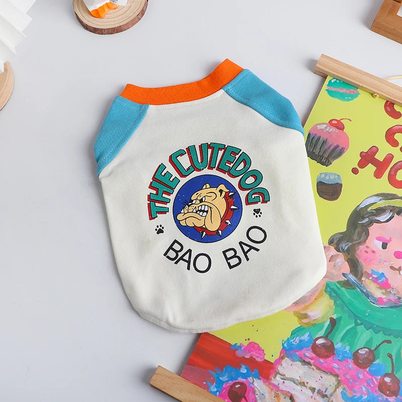 A white dog vest with blue trim and orange collar featuring a graphic of a cute dog face and the text THE CUTEDOG BAO BAO