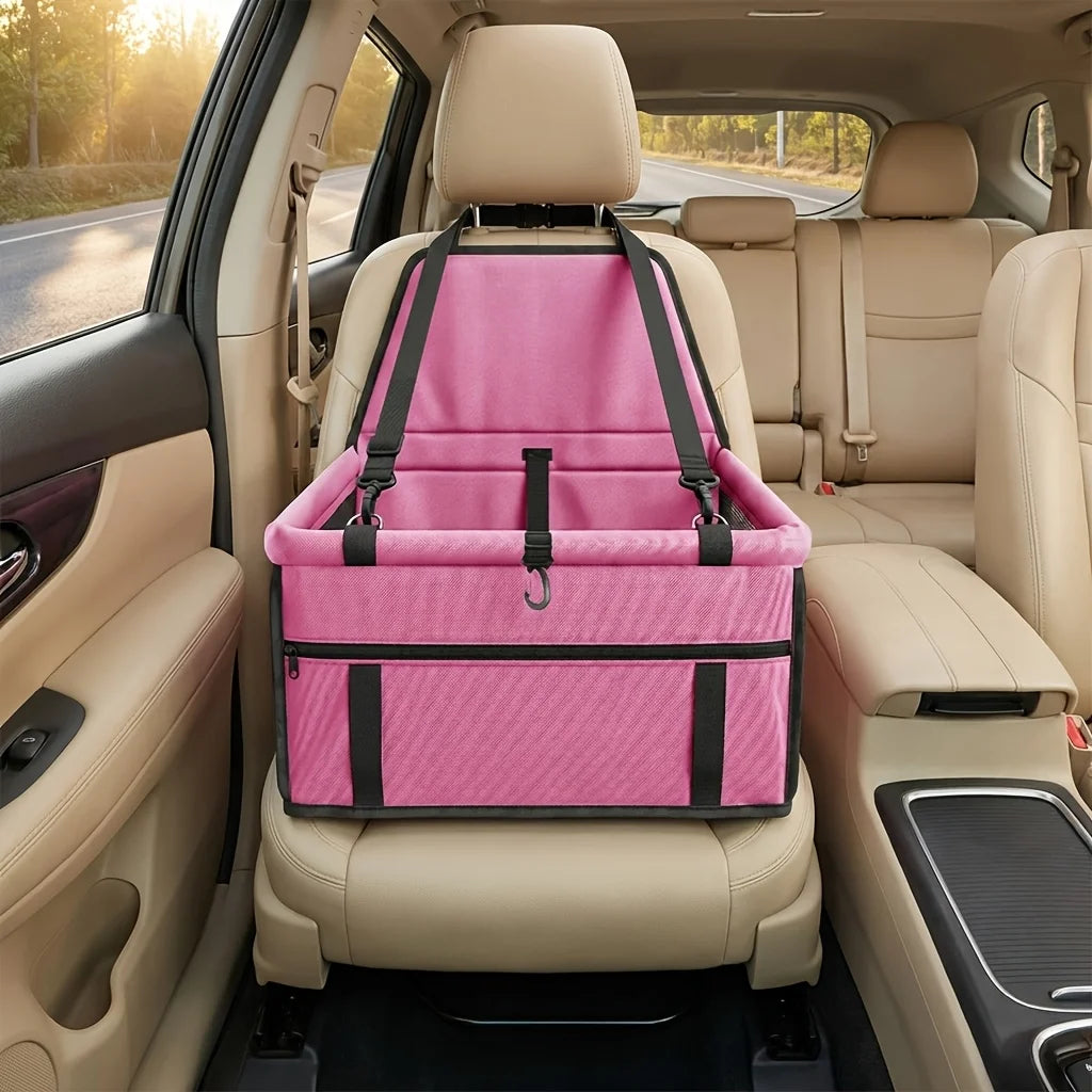 Pink portable dog car seat travel carrier with adjustable safety straps installed in a vehicle interior.