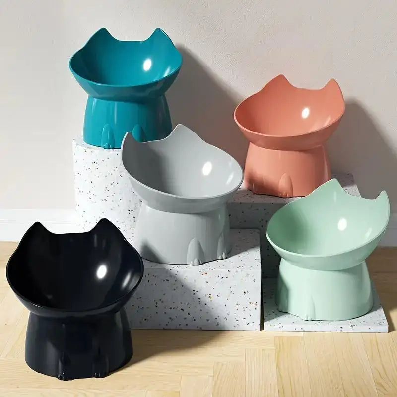 A collection of five elevated cat bowls in various pastel and dark colors displayed on a light wooden surface.