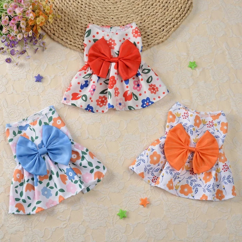 An adorable lace bow pet dress for small dogs and cats in orange and blue floral patterns.