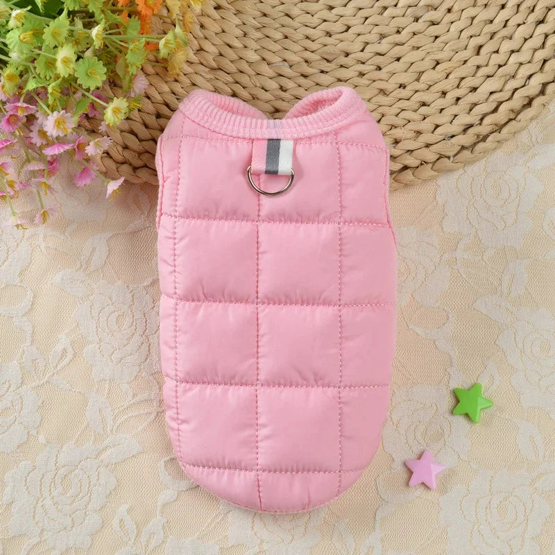 Manteau de chien rembourré et imperméable à pois roses pour petits chiens, posé sur un tissu clair avec de la verdure en arri