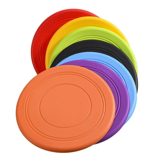 A stack of colorful silicone flying saucer pet toys in shades of red, yellow, green, black, and purple.
