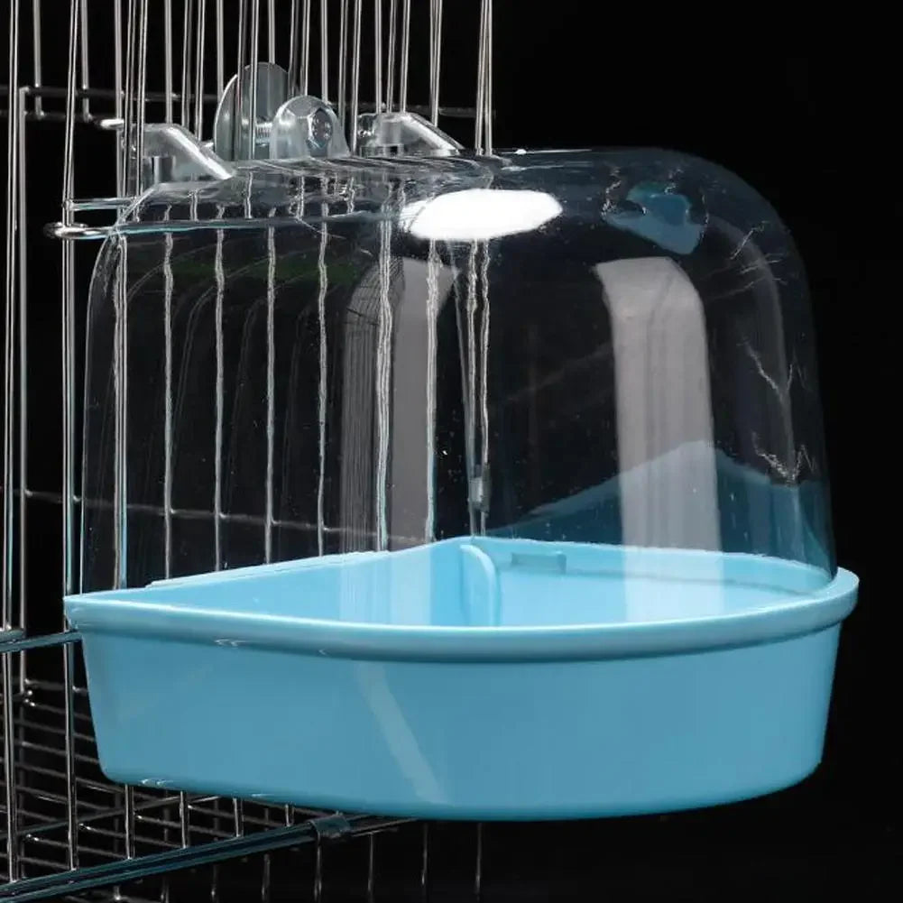 Ein durchsichtiges, hängendes Vogelbad für Sittiche ist in einem Drahtgitter aufgehängt.