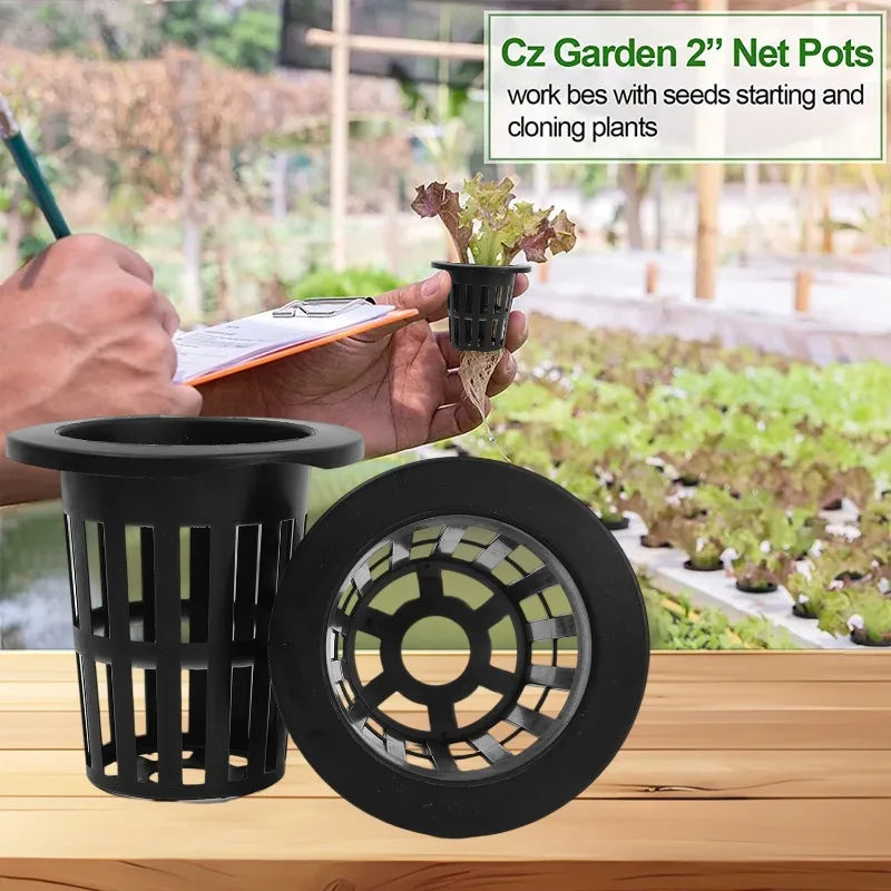 A hand is holding a small plant in a black mesh net pot, next to a larger black disk-shaped net pot.
