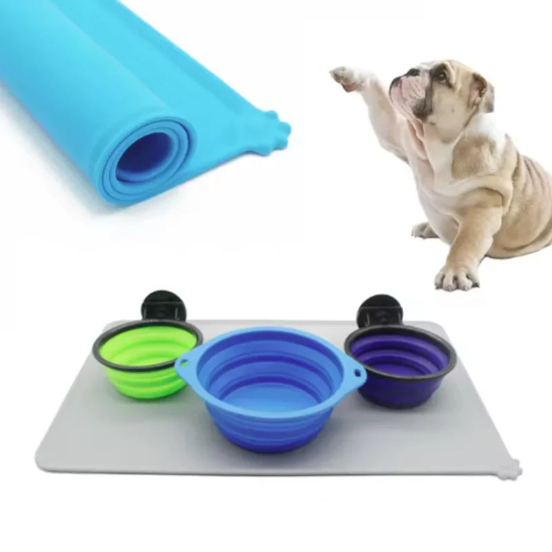 A blue silicone pet feeding mat with multiple colored bowls and a rolled silicone mat shown next to a dog.