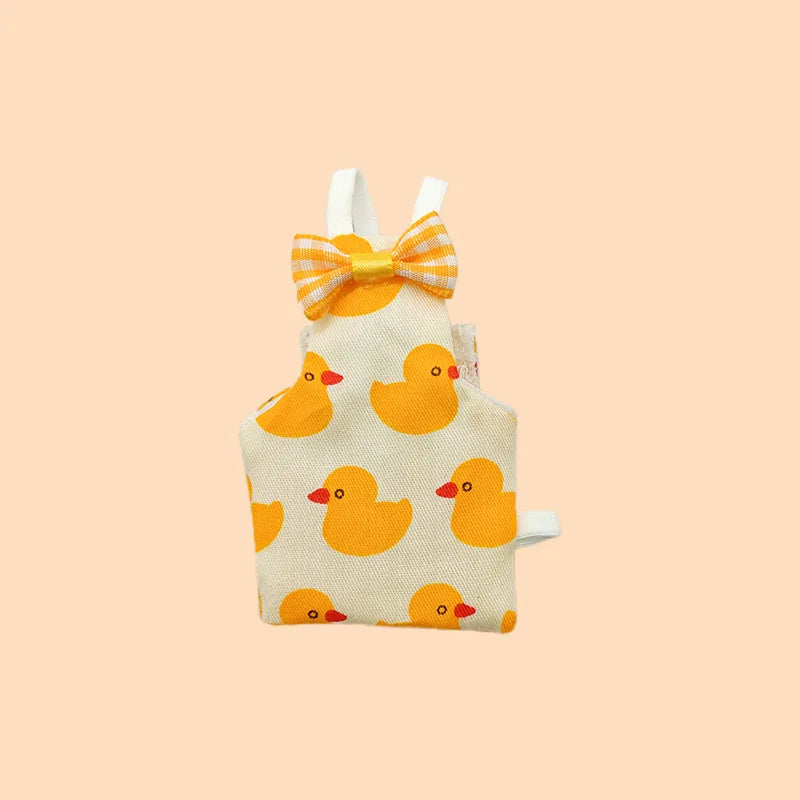 Traje de vuelo amarillo lavable para loros con lazo de pañal sobre fondo beige claro.