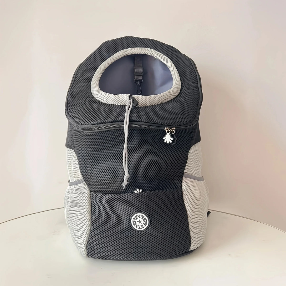 Beige und graues, bequemes Hundeträger-Rucksack mit hellem grauem Innenfutter und silbernem Anhänger.