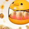 A yellow home egg incubator is shown with several bird eggs inside, next to some chicks and straw.