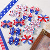 A collection of red, white, and blue star patterned ribbon hair bows with clips arranged on a white surface.