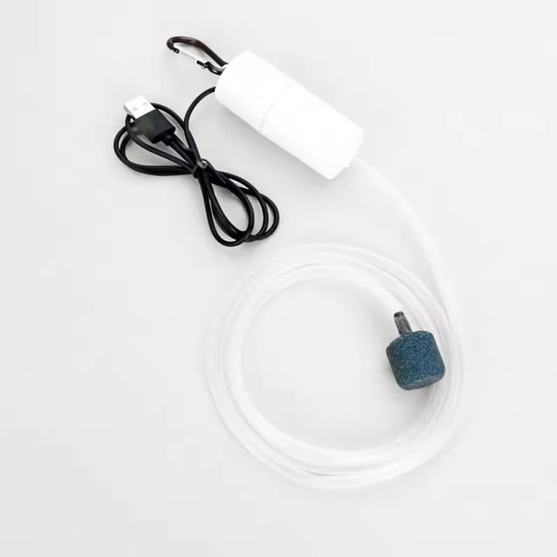 A white USB aquarium air pump with a black cord and clear tubing is shown on a white background.