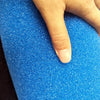 A hand is touching a bright blue, porous sponge filter used for aquarium biochemical filtration.