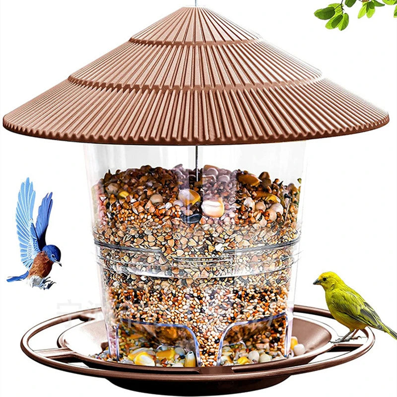 Nourrice à oiseaux étanche avec toit conique rempli de graines, posée sur un plateau marron.