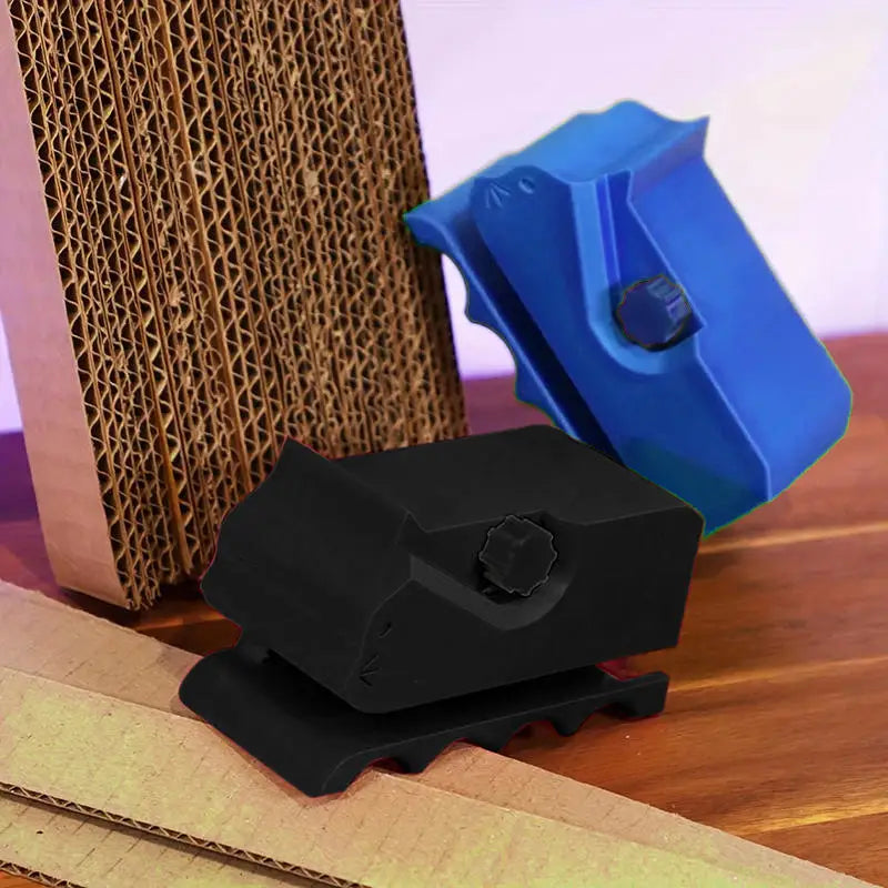 A black handheld cardboard strip cutter rests on a brown corrugated cardboard box and a piece of light brown paper.