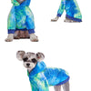 Un petit chien portant un sweat à capuche en polaire tie-dye bleu et vert.