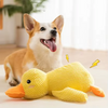 A golden retriever puppy sits next to a yellow plush duck toy.