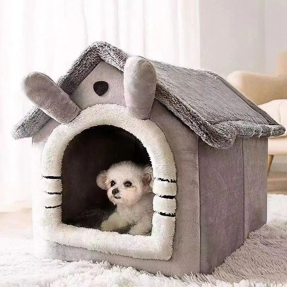 Tente grise pour animal avec toit en bois et entrée arquée, montrant un petit chiot blanc à l'intérieur.