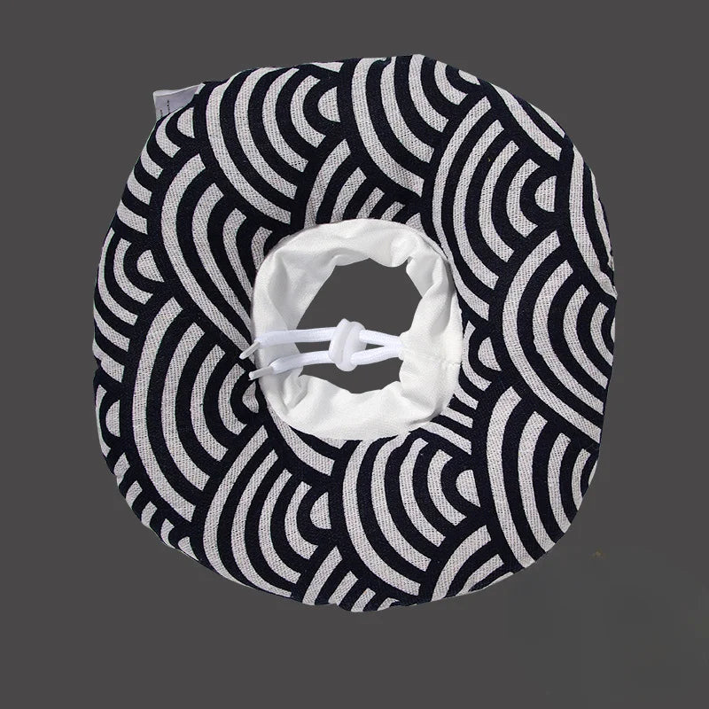 A black and white patterned soft cotton recovery collar for dogs and cats with a white adjustable opening.