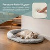 A fluffy white cat is resting on a gray cooling ice silk pet mat indoors.