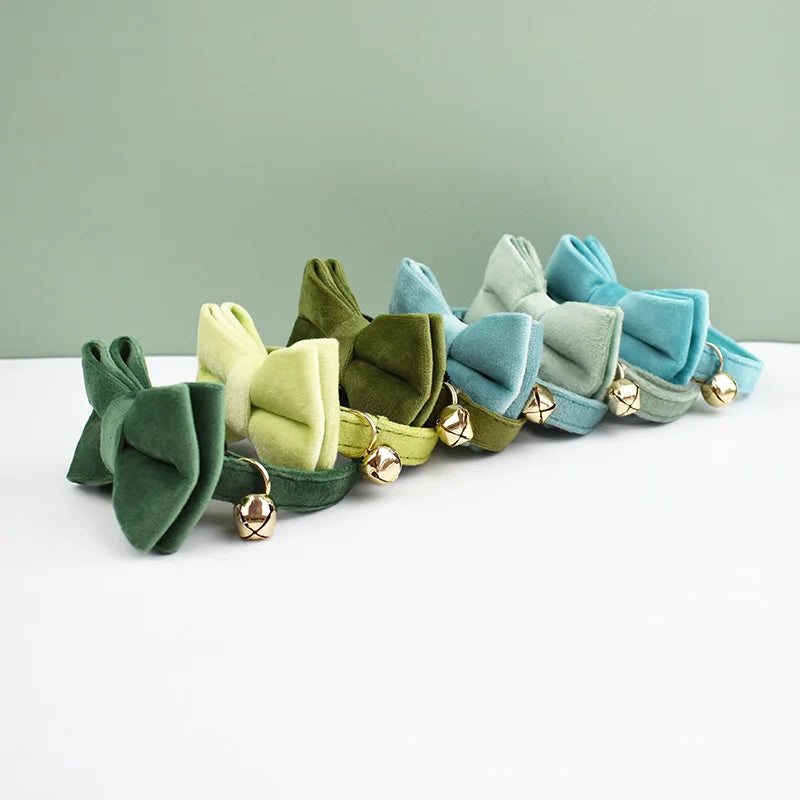 A collection of velvet cat collars in shades of green and blue with gold safety buckles