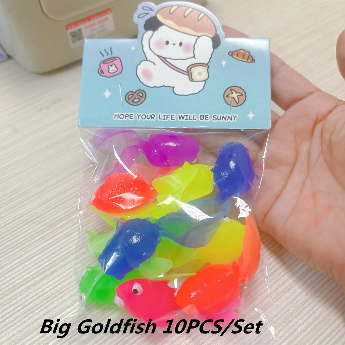 A clear plastic bag containing ten colorful rubber goldfish bath toys for kids.