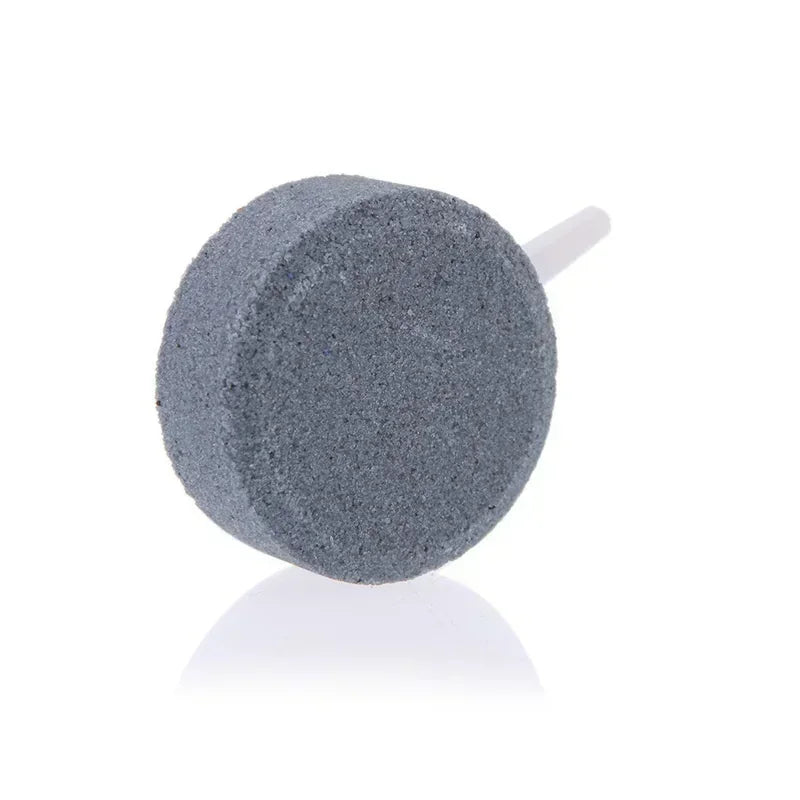 A grey air stone disc used for aquarium aeration.