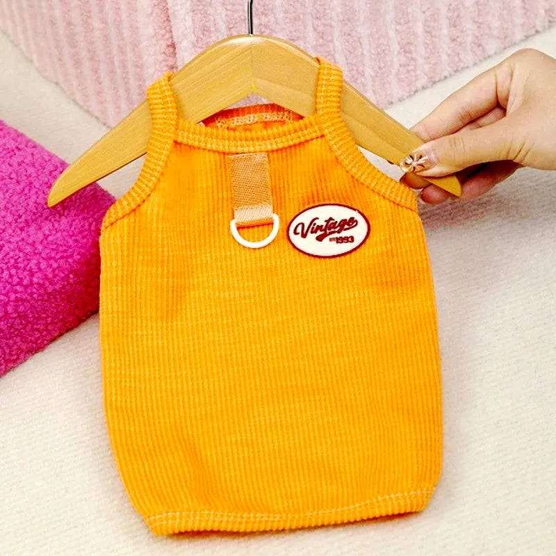 Orange gestricktes Kühlvest für Hunde, aufgehängt an einem Holzbügel