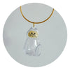 A clear glass charm shaped like a cat's head hangs from a gold-colored cord.