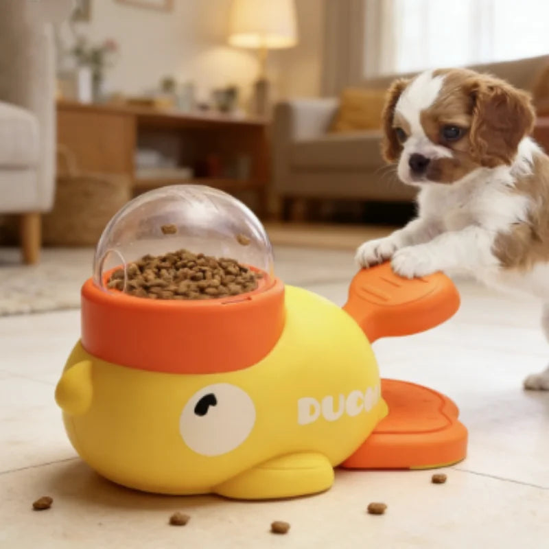 A small dog is interacting with a yellow duck-shaped slow feeder puzzle toy for dogs.