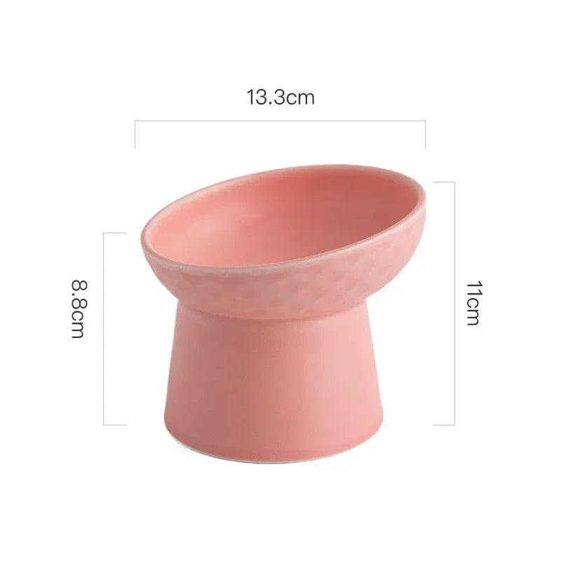 A pink elevated ceramic food bowl for pets, showing its size and shape.