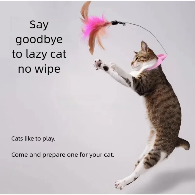 A tabby cat is playfully batting at a pink feather toy attached to a string.