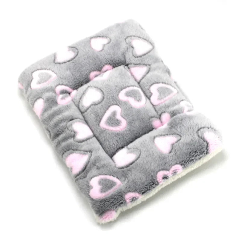 A gray plush fleece pet blanket or bed mat with pink heart patterns for dogs and cats.