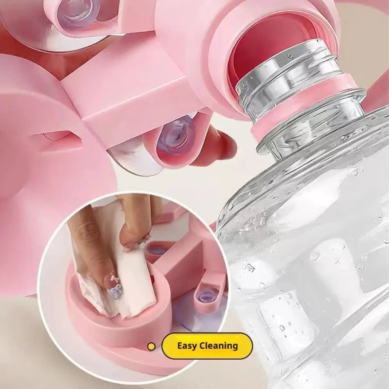 A pink gravity cat water dispenser is shown with a hand cleaning the bowl, highlighting easy cleaning features.