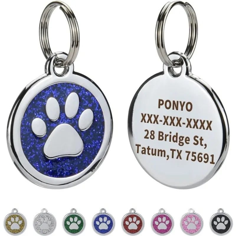 Silver pendant with a blue paw print and engraved text on a white background