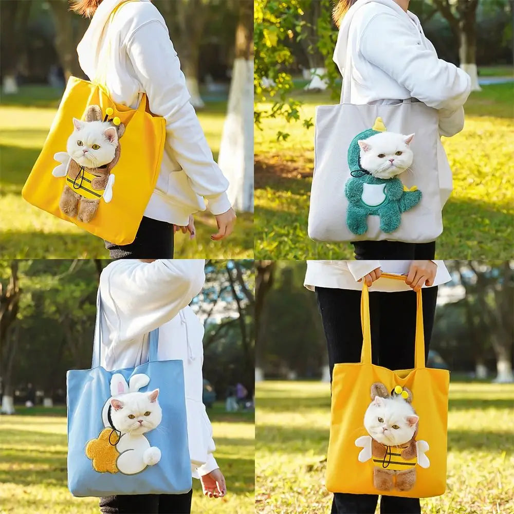 A person is holding a yellow canvas pet carrier bag with a fluffy cat toy and a white hoodie in an outdoor park setting.