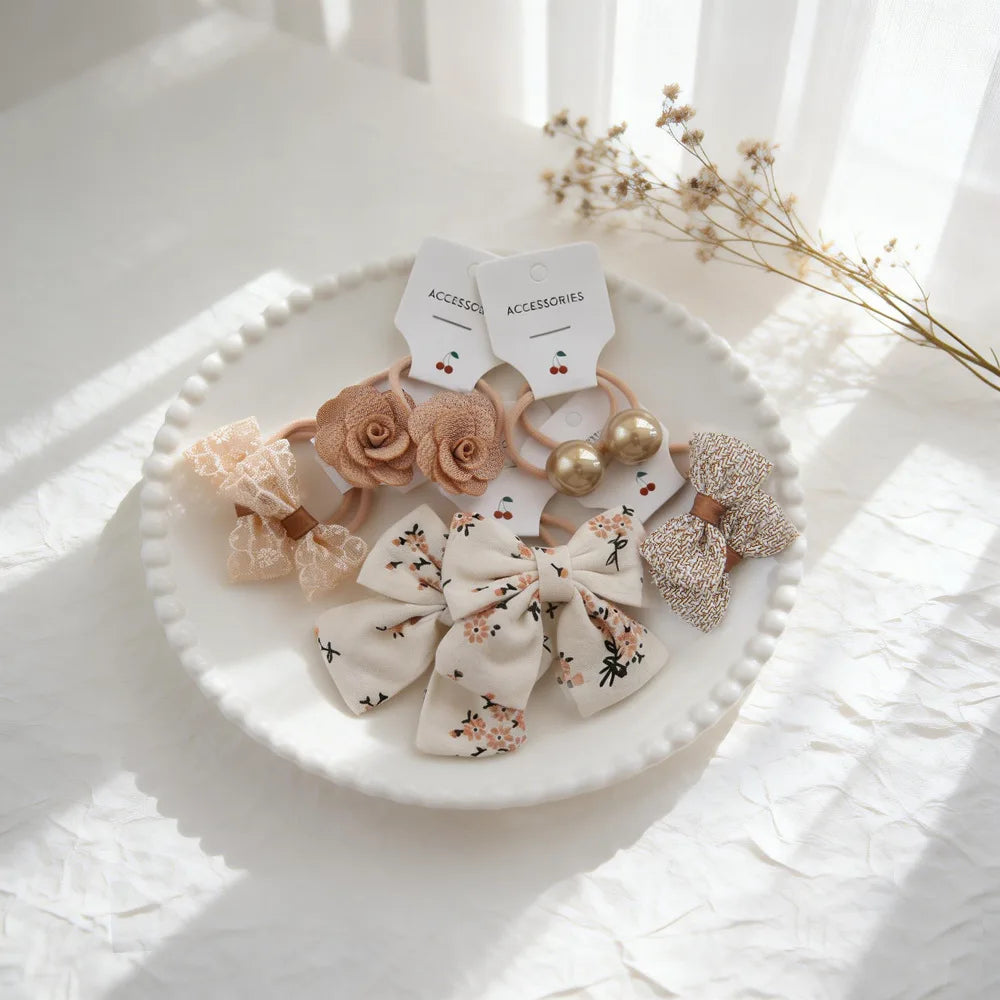 Présentation de divers nœuds élastiques pour cheveux et accessoires, y compris des nœuds en tissu rose, des accents de perles