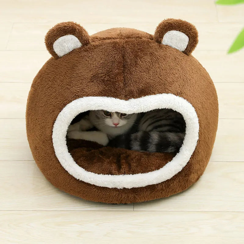 Un lit-cocon de chat en peluche marron avec de grandes oreilles et une ouverture pour le chat