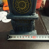Horloge en 3D imprimée bleu foncé avec cadran circulaire doré et base architecturale.