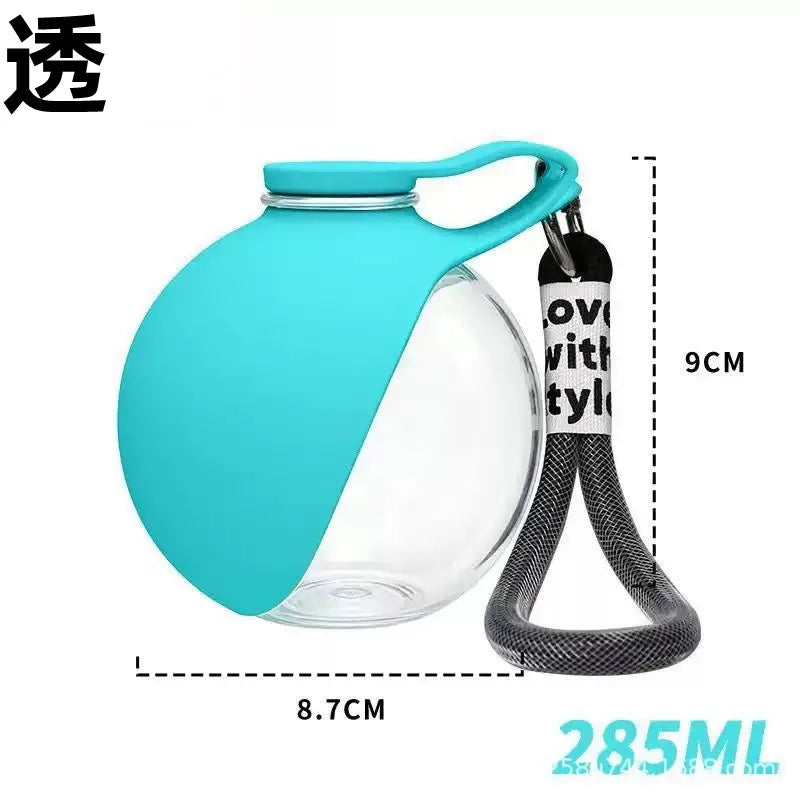 A teal glass water dispenser with a hinged lid and a black strap for carrying, shown against a white background.
