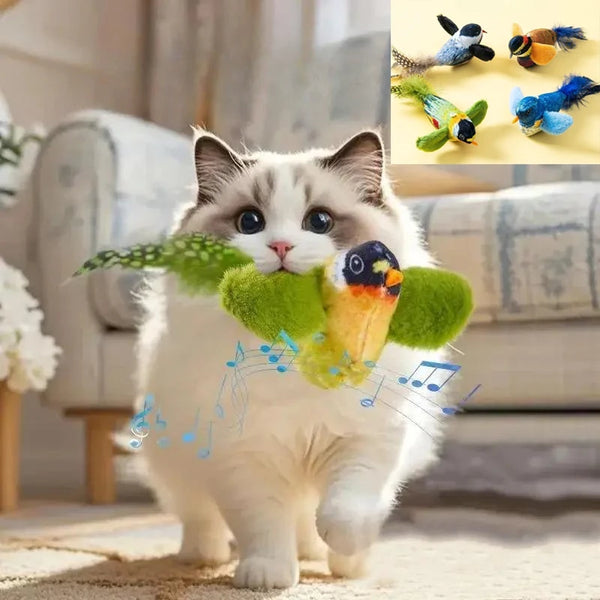 A white cat is playing with a green feather toy, surrounded by colorful bird toys.