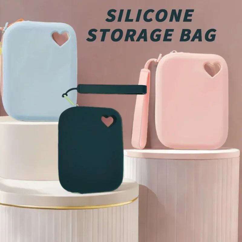 A set of silicone storage bags in light blue and pink, including a rectangular bag and a heart-shaped pouch.