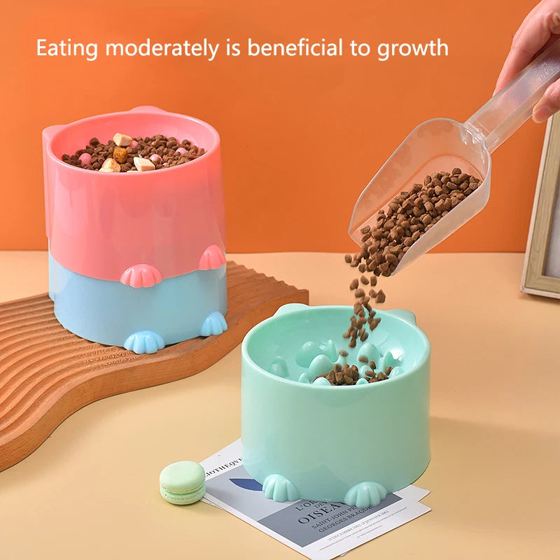 A slow feeder bowl for pets is shown with dry food being poured into it, next to a wooden board and a product label.