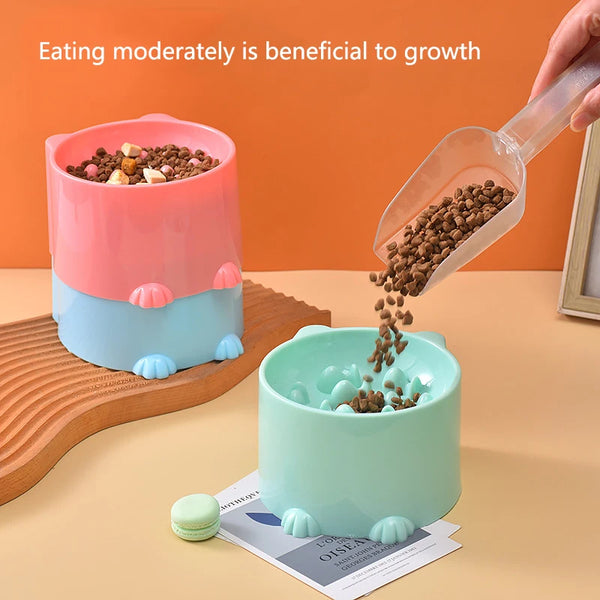 A slow feeder bowl for pets is shown with dry food being poured into it, next to a wooden board and a product label.