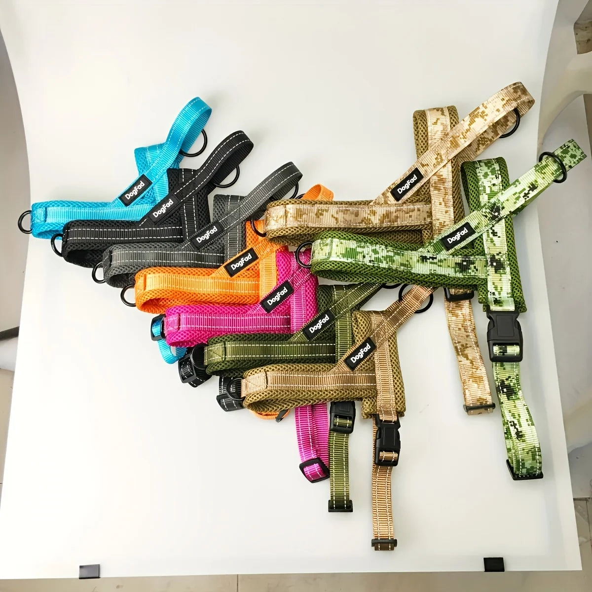 A collection of colorful reflective no-pull dog harnesses displayed on a white surface.