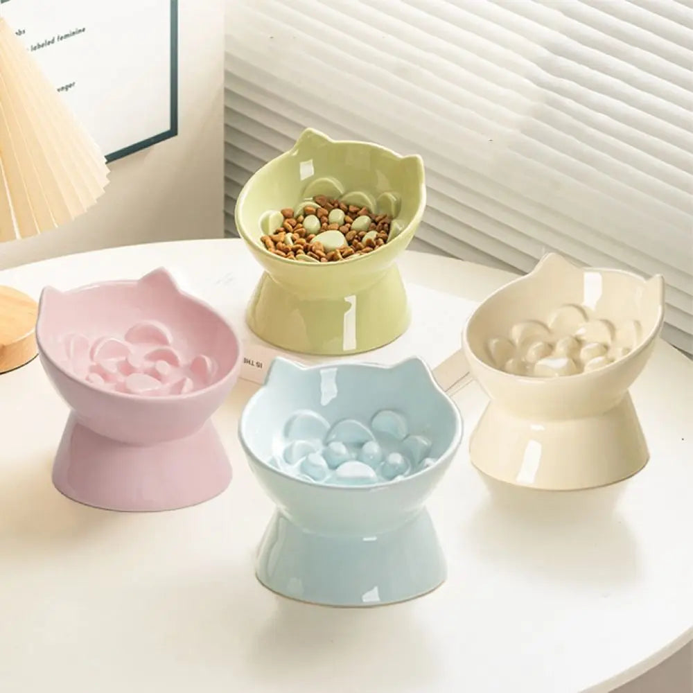 A collection of ceramic pet food bowls in various pastel shades, including green, pink, blue, and cream.