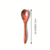A single wooden tea or coffee spoon with a reddish-brown finish shown next to a vertical measurement scale.