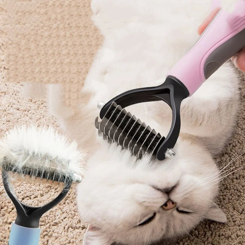 A pink pet deshedding comb is being used on a white cat resting on a beige surface.