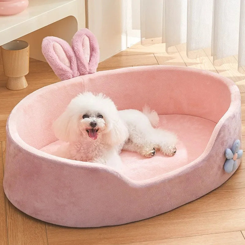 A pink plush pet bed with a removable cover is shown containing a white fluffy dog.