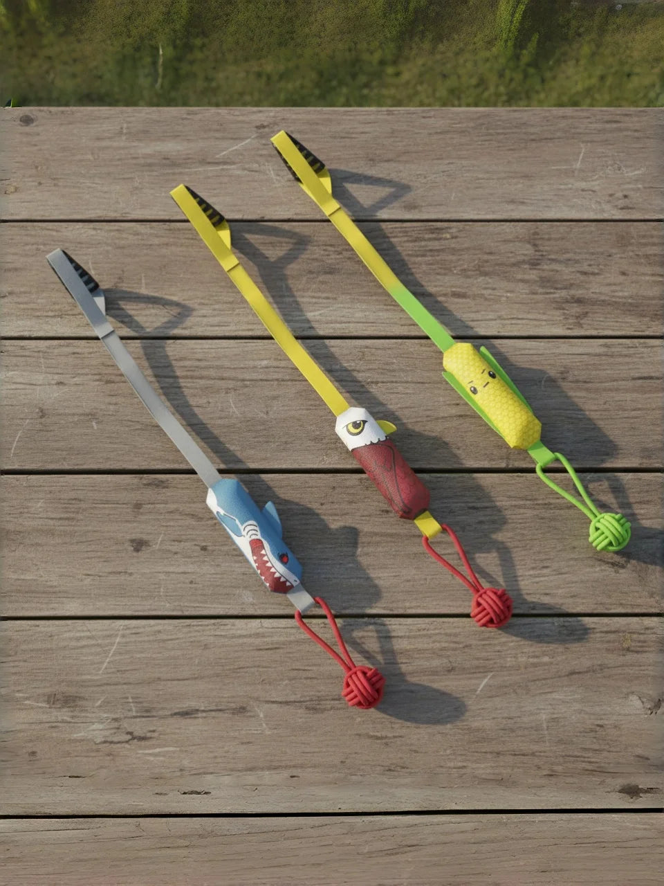A yellow and green interactive shark rope tug toy with a suction cup is displayed on a wooden surface.