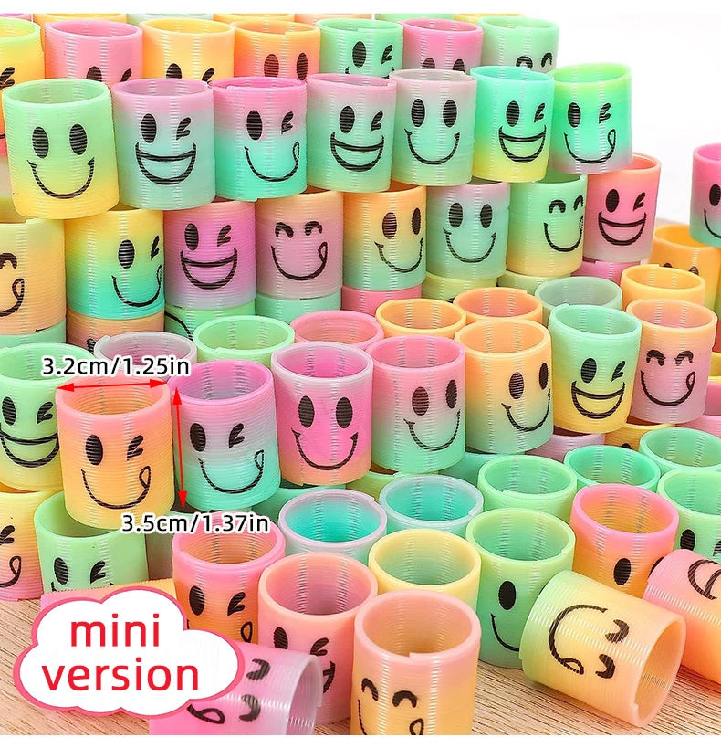 A set of twelve colorful spring coil toys featuring smiley faces in various shades of pink, yellow, and green.